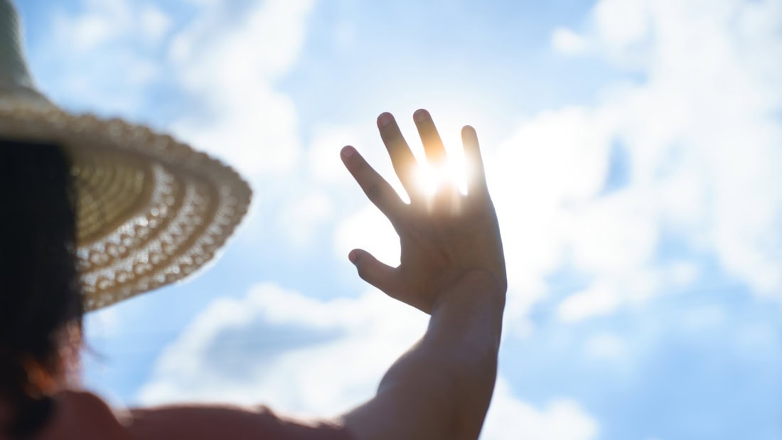 Zonneschijn en hand die de zon bedekt tijdens hittegolf hitteplan in Nederland.